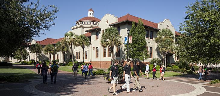 Photo of West Hall with students walking by.
